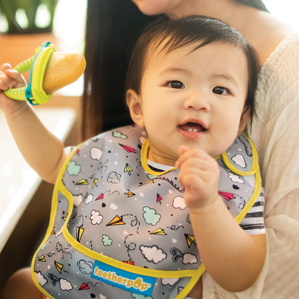 Happy baby wearing a bib with Teetherpop™